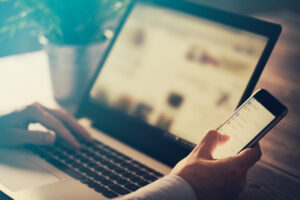 Man using laptop and phone.